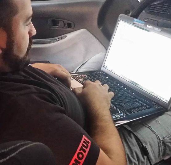Insane Garage persona revisando coche con computador